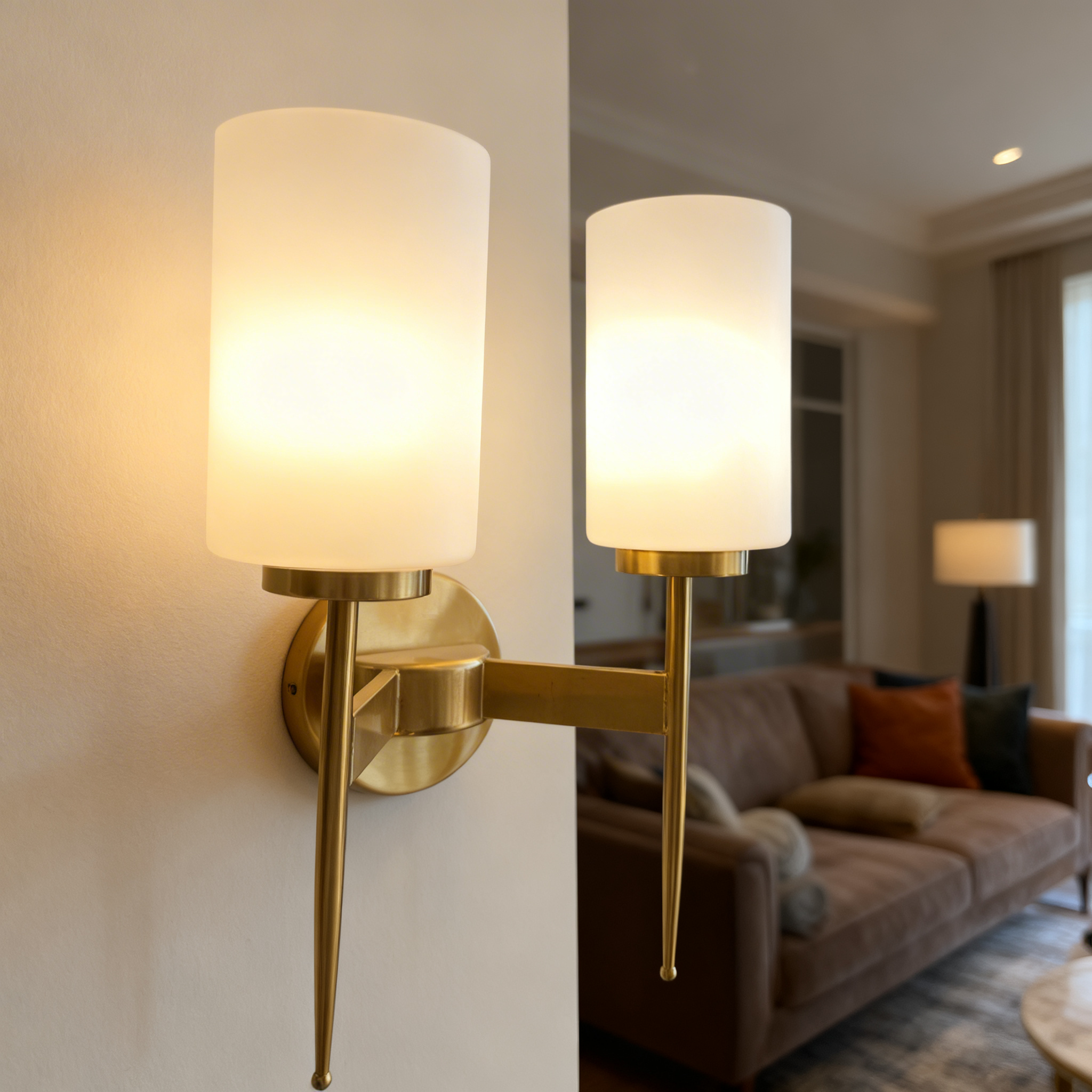 Alternative view of modern brass wall sconce featuring a cylindrical white glass shade and a pencil-style metal arm