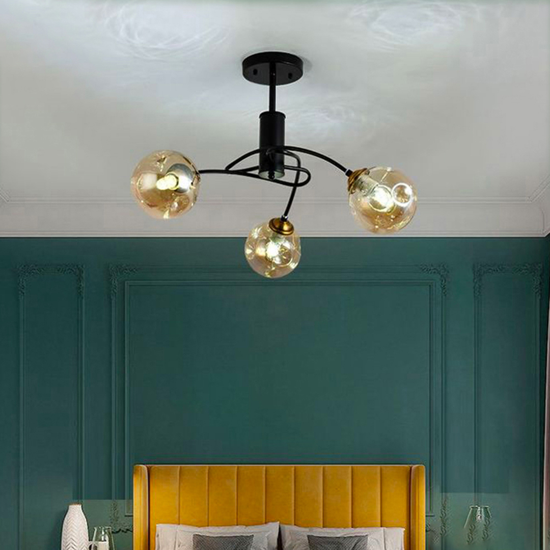 3-light semi-flush mount ceiling fixture with a black iron body and amber globe glass shades. 