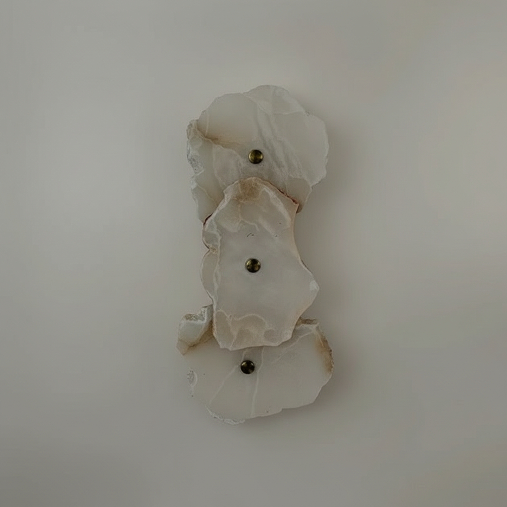 modern decorative wall sconce featuring irregular, translucent white marble or alabaster plates paired with brass or copper metal hardware